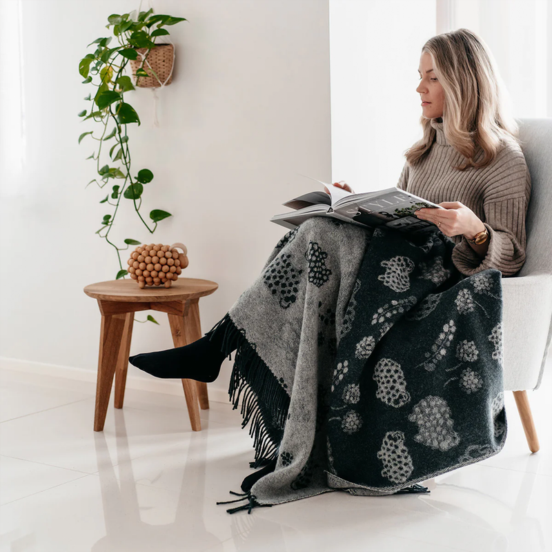 woman wrapped up in Aarikka Rams in a Field Wool Blanket, dark green