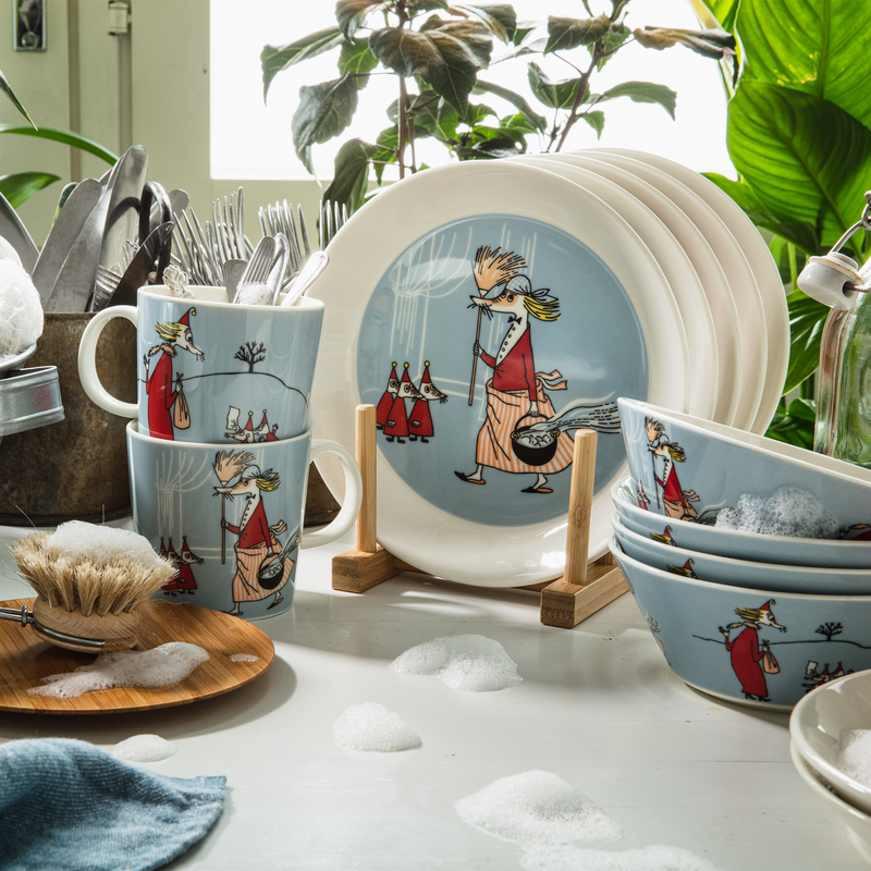 Dishware set with cartoon characters on a white surface with plants in the background