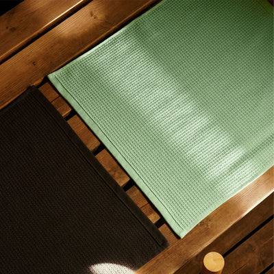 Green textured mat on a wooden surface
