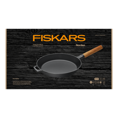 Fiskars frying pan with wooden handle on a black wooden background