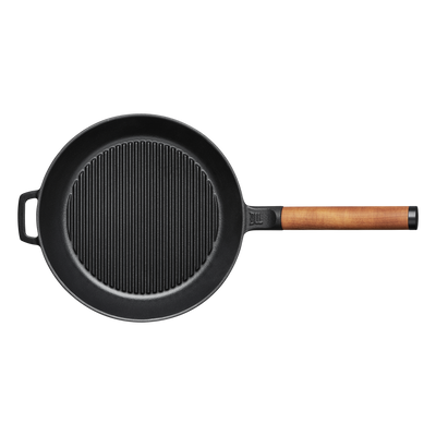 Black cast iron skillet with a wooden handle on a white background