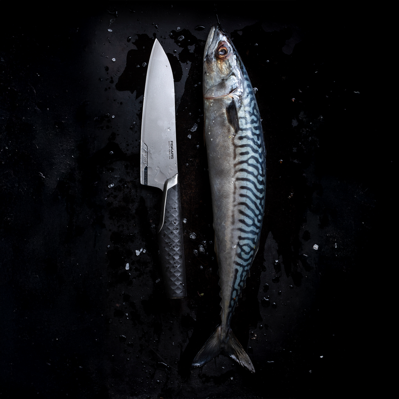 Fish and knife on a dark surface