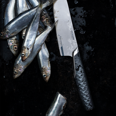 Small fish and a knife on a dark surface with 'Fischer' branding.