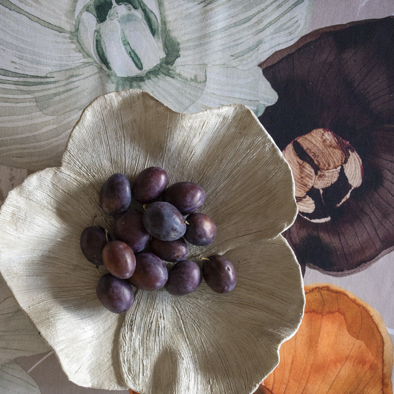 Purple fruits on a large beige flower petal with floral background