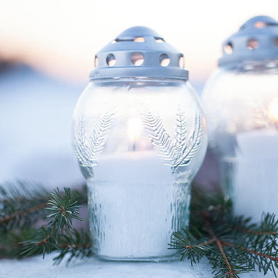 Decorative glass lanterns with snow-covered branches in the background