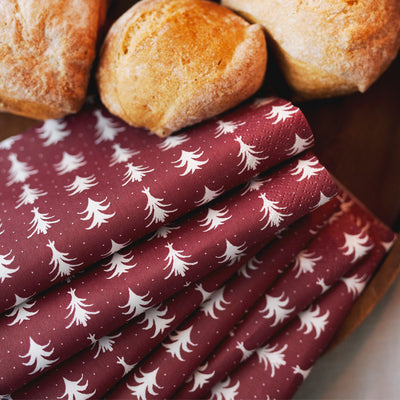 Red fabric with white tree pattern next to bread rolls