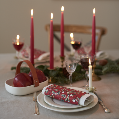 Dining table set for a meal with candles, wine glasses, and decorative items.