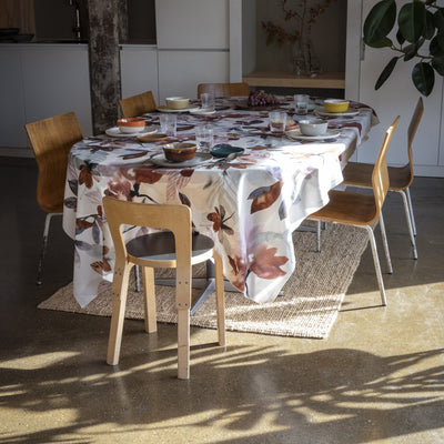 Dining table set with a floral tablecloth in a modern kitchen.