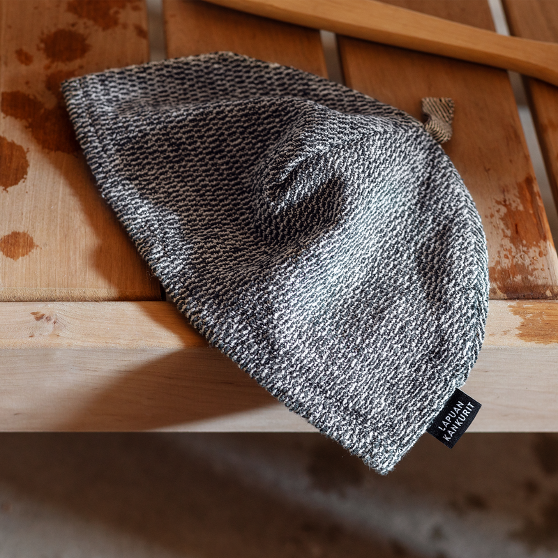 Gray knit beanie with a brand tag on a wooden surface
