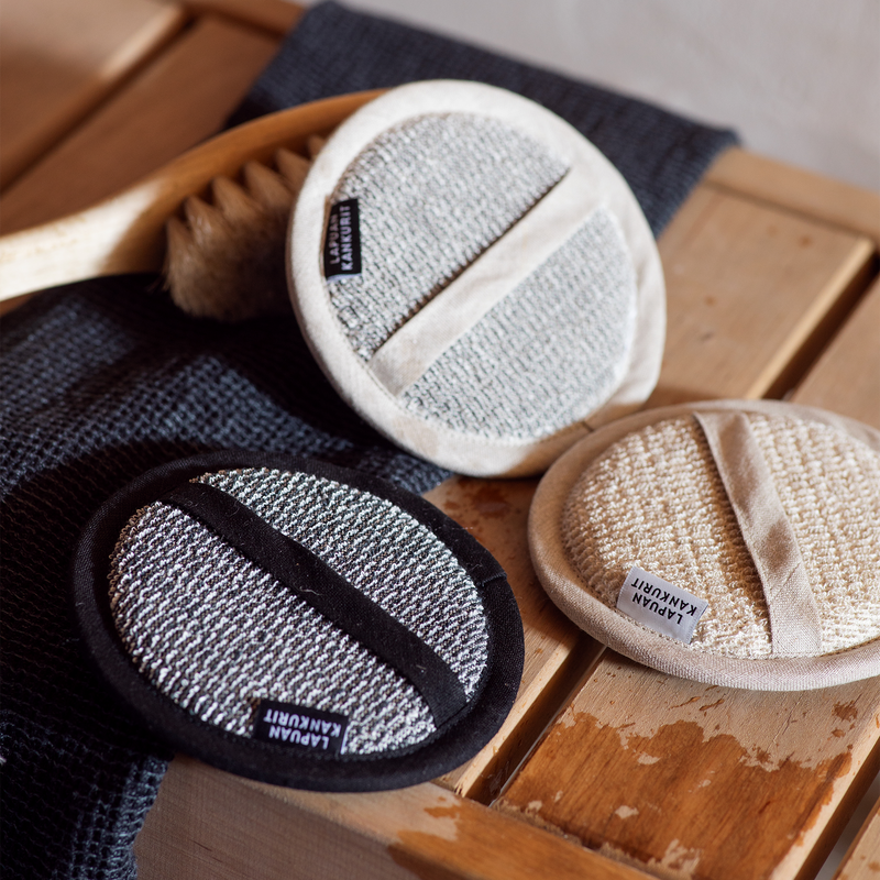 Three exfoliating pads on a wooden surface with a blurred background