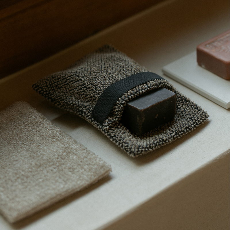 Bar of soap on a textured towel with a wooden background