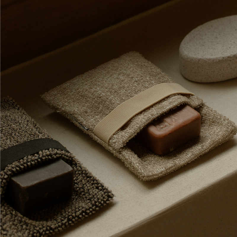 Two bars of soap on textured cloths with a neutral background