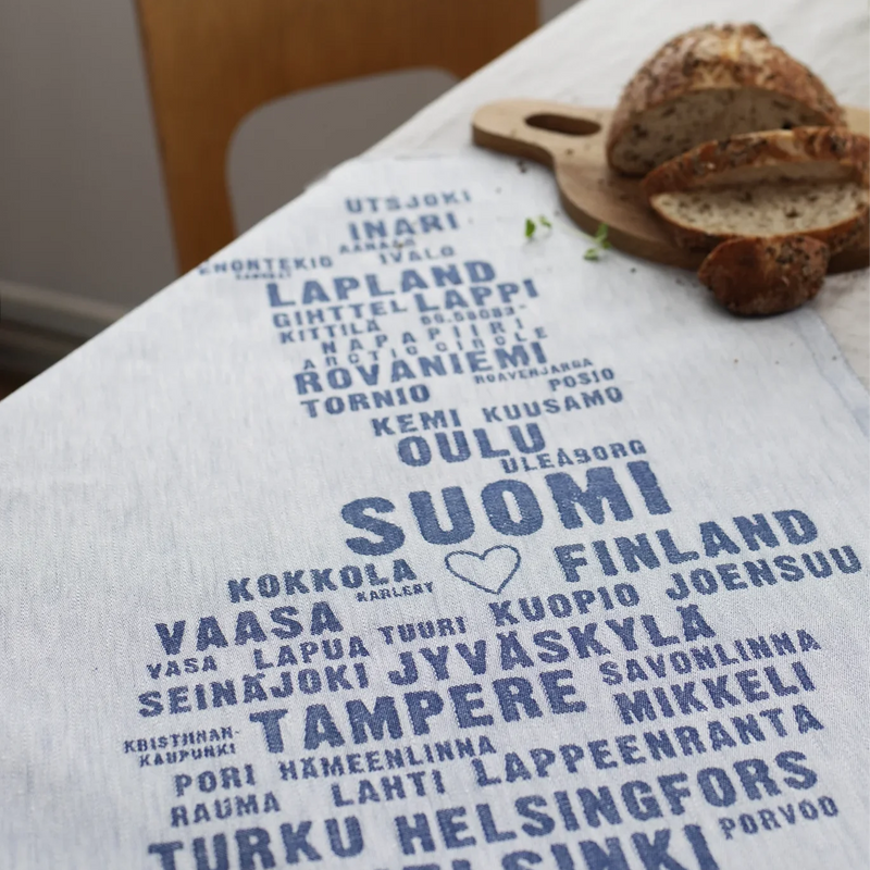 Tablecloth with text of Finnish cities on a table with bread