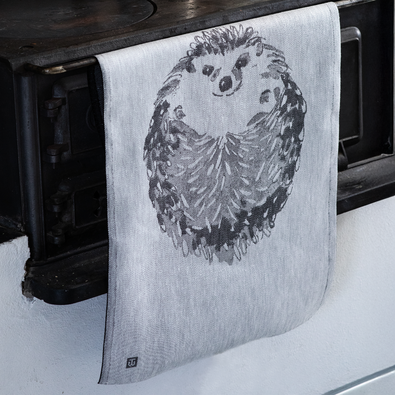 Towel with hedgehog design hanging on a wooden rack