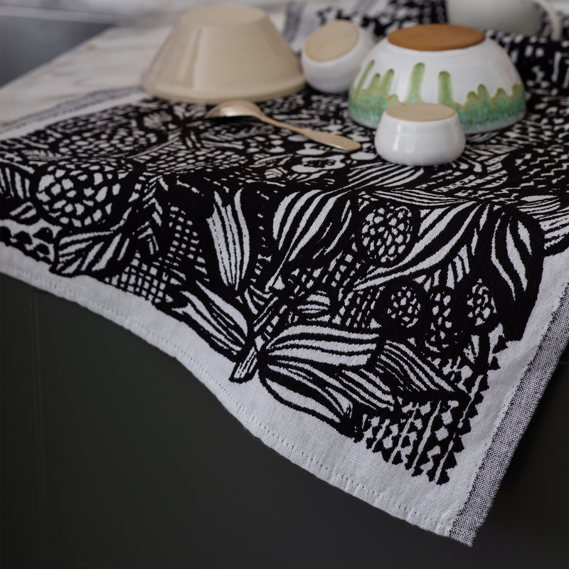 Black and white patterned towel on a table with ceramic items