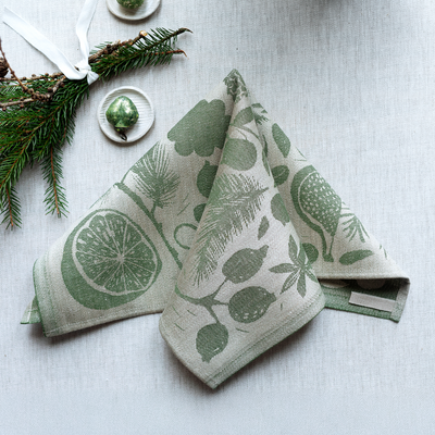 Two green patterned towels on a light gray surface with decorative elements.