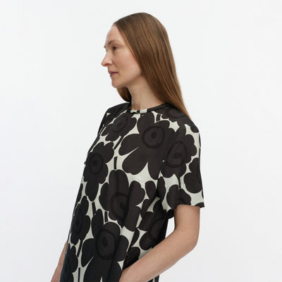 Woman wearing a black and white floral dress on a plain background