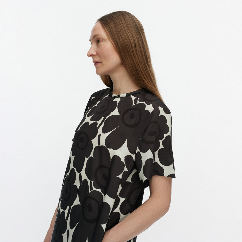 Woman wearing a black and white floral dress on a plain background