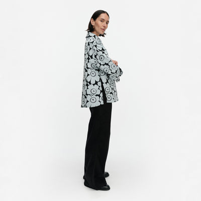 Person wearing a black and white floral patterned jacket on a white background