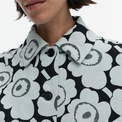 Close-up of a person wearing a black and white floral patterned coat.