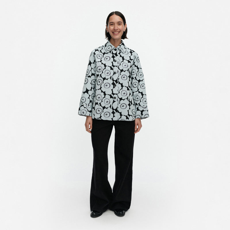 Person wearing a black and white floral patterned jacket on a white background