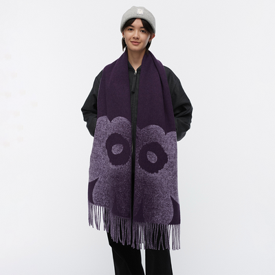 Person wearing a purple scarf with fringe on a white background