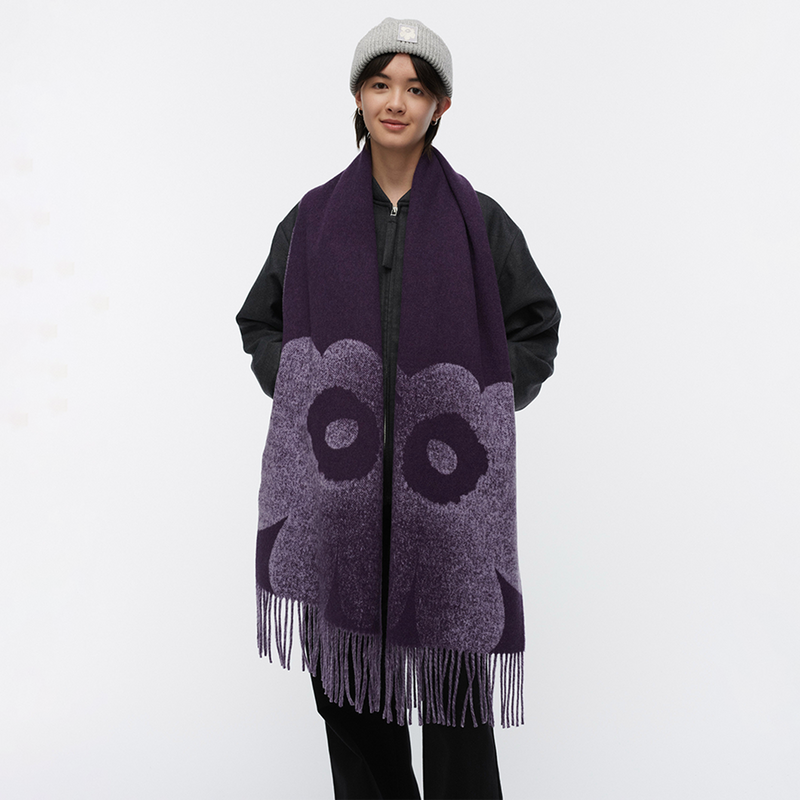 Person wearing a purple scarf with fringe on a white background
