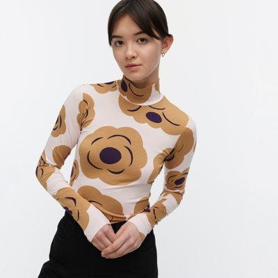 Woman wearing a long-sleeve top with a brown floral pattern on a white background