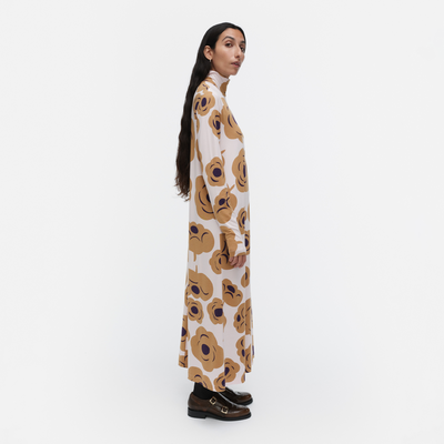 Woman wearing a long floral dress on a white background