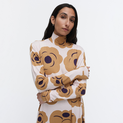 Woman wearing a sweater with emoji face patterns on a white background