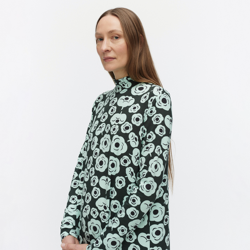 Woman wearing a black floral patterned shirt on a white background