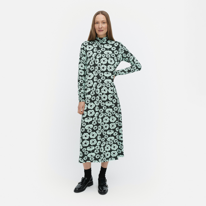 Woman wearing a green floral dress on a white background