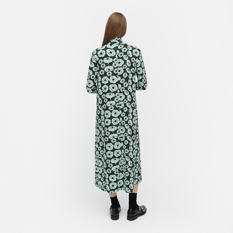 Person wearing a green floral dress on a white background