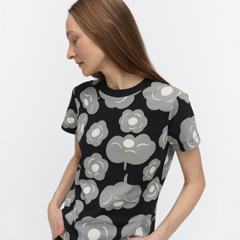 Woman wearing a black t-shirt with gray floral pattern on a white background