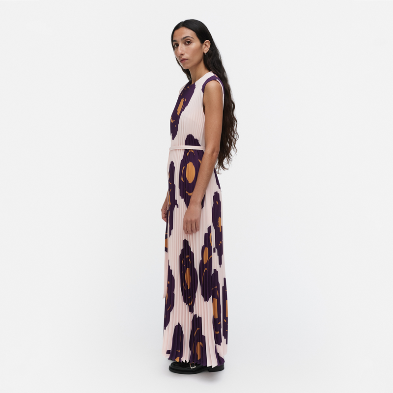 Woman wearing a sleeveless dress with abstract pattern on a white background