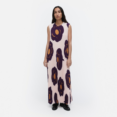 Woman wearing a sleeveless dress with large floral patterns on a white background