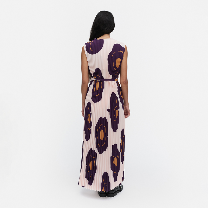 Woman wearing a long dress with a floral pattern on a white background