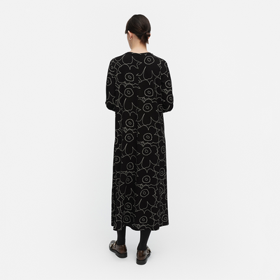 Person wearing a black patterned dress on a white background