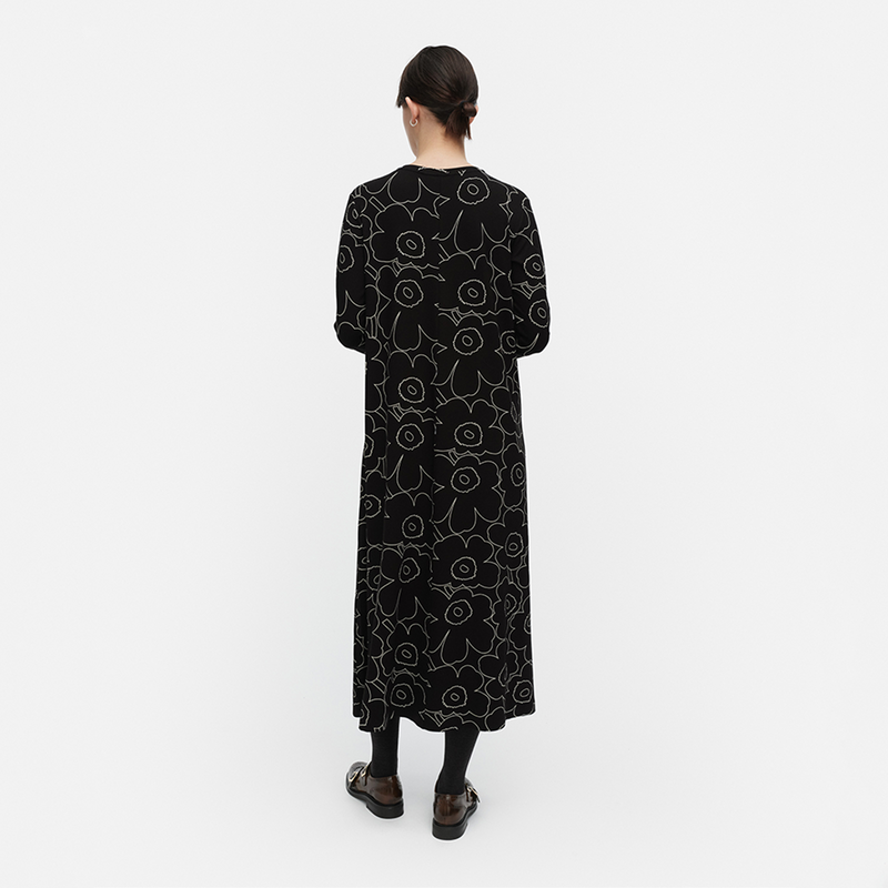 Person wearing a black patterned dress on a white background