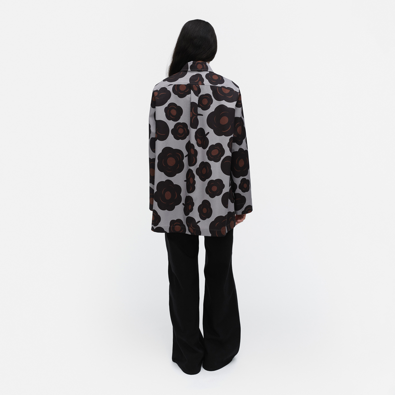 Person wearing a patterned coat on a white background