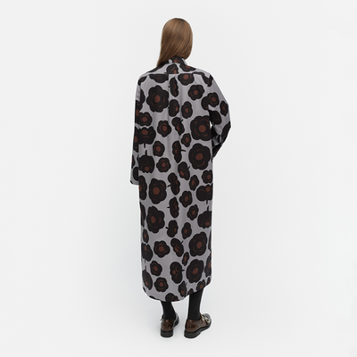 Person wearing a long, patterned coat on a white background