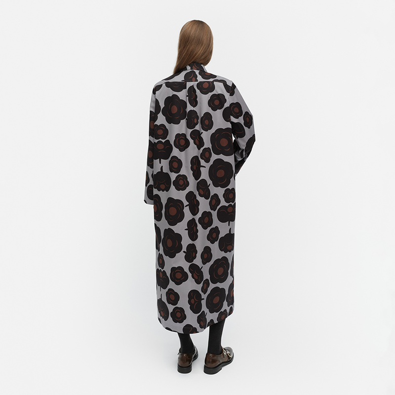 Person wearing a long, patterned coat on a white background