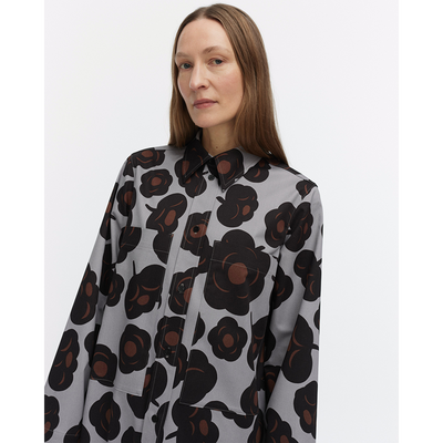 Woman wearing a floral patterned shirt on a white background