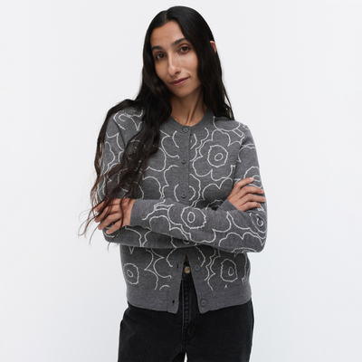 Woman wearing a gray cardigan with floral patterns on a white background