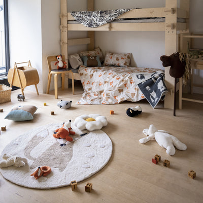 Children's room with bunk bed, toys, and a round rug.