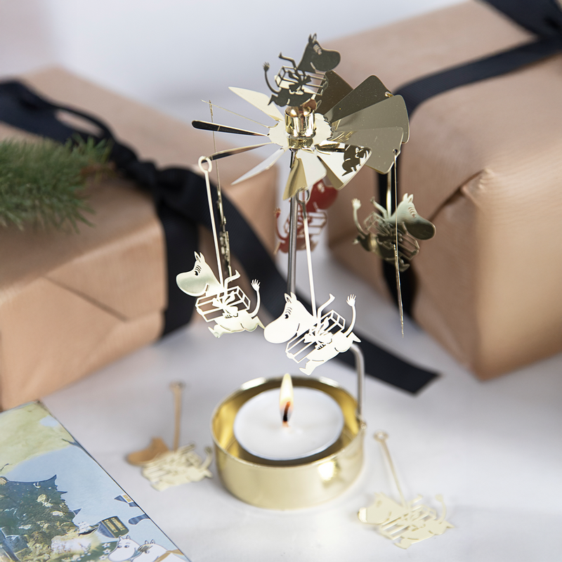 Decorative candle holder with windmill and sheep design on a white surface.