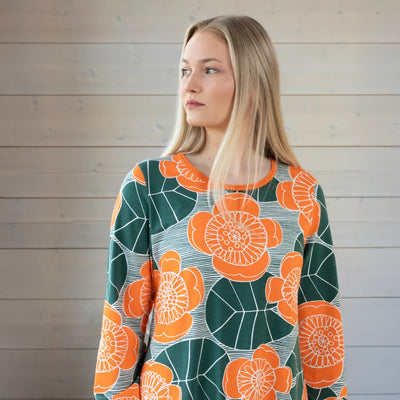 Woman wearing a floral patterned sweater against a wooden background