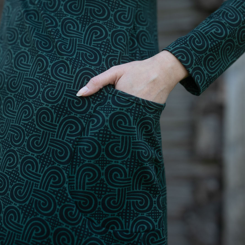 scooped pocket of looped square dark green tunic