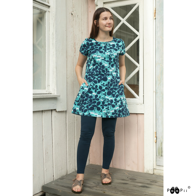 Woman standing on porch wearing Paapii Lyyra Tunic Clover in turquoise