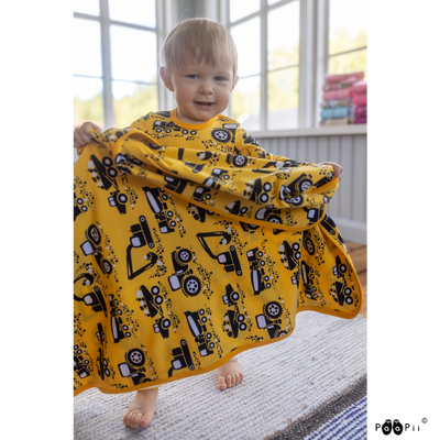 toddler holding yellow machines blanket